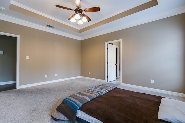 bedroom with crown molding, ceiling fan, a raised ceiling, and carpet