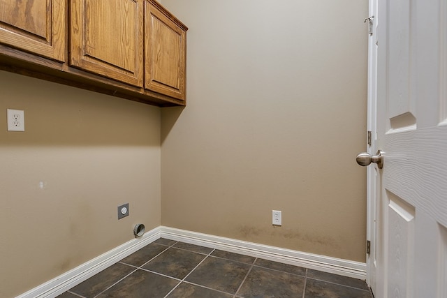 laundry area with cabinets, hookup for an electric dryer, and dark tile patterned floors