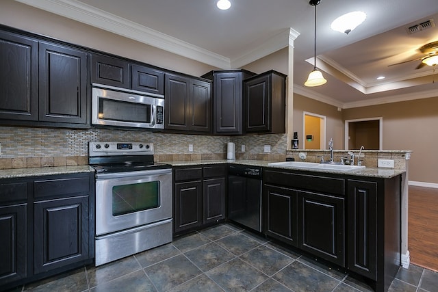 kitchen with sink, hanging light fixtures, stainless steel appliances, decorative backsplash, and kitchen peninsula