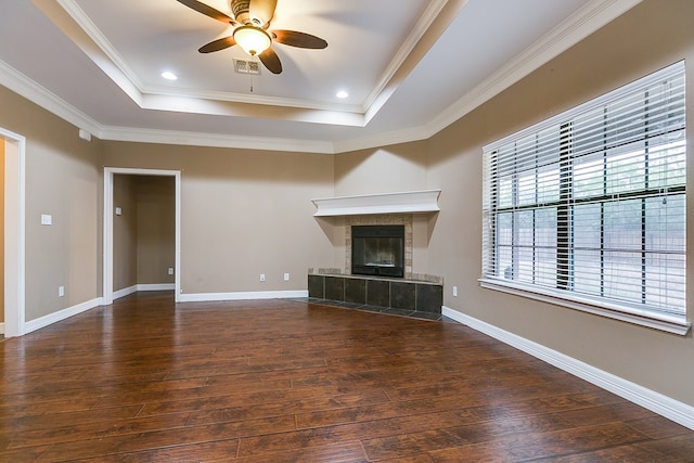 unfurnished living room featuring ornamental molding, dark hardwood / wood-style flooring, and a raised ceiling