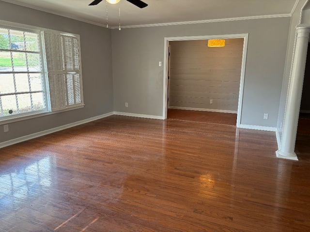 spare room with crown molding, ceiling fan, dark hardwood / wood-style flooring, and decorative columns