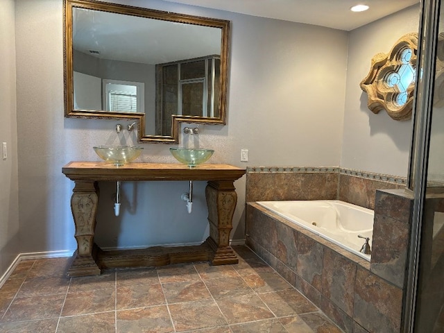 2661 Oxford Ave, San Angelo, TX 76904 - bathroom featuring tiled bath and sink
