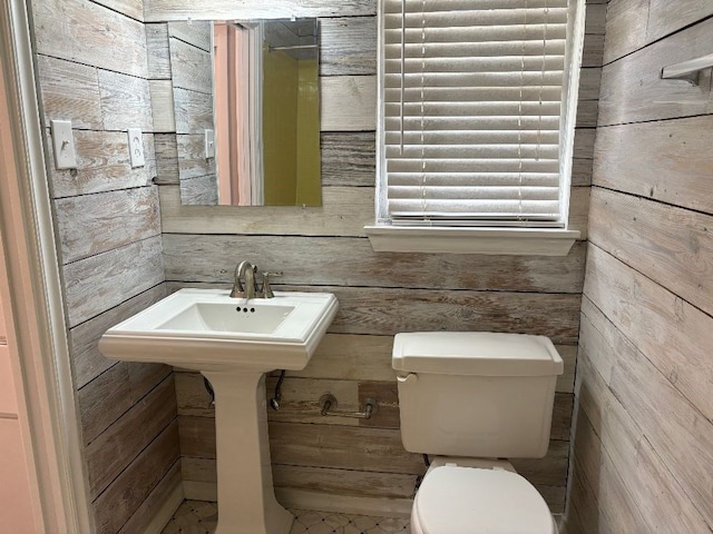 bathroom featuring toilet and wood walls