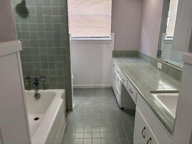 bathroom with vanity, a tub, and plenty of natural light