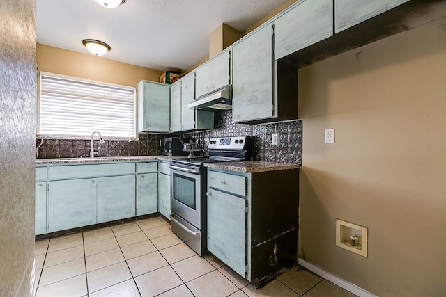 3101 Grove Dr, San Angelo, TX 76903 - kitchen featuring stainless steel range with electric stovetop, under cabinet range hood, decorative backsplash, light tile patterned floors, and a sink