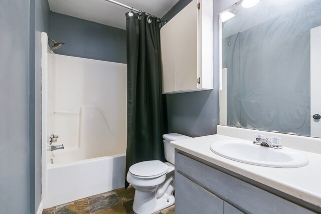 3101 Grove Dr, San Angelo, TX 76903 - bathroom featuring shower / tub combo with curtain, stone finish flooring, vanity, and toilet