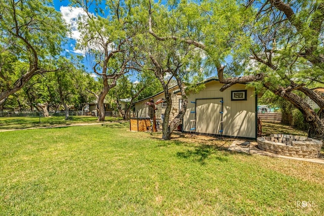 view of yard with an outdoor fire pit and a shed