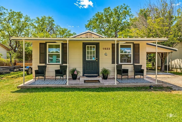 view of front facade with a front yard, a carport, and a porch