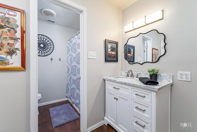 bathroom with vanity, wood-type flooring, and toilet