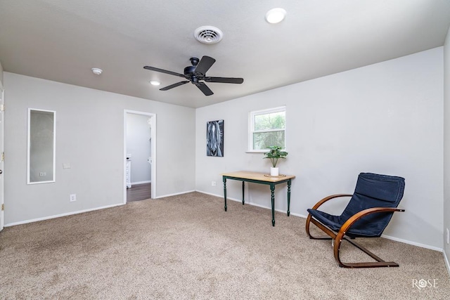 living area with carpet and ceiling fan