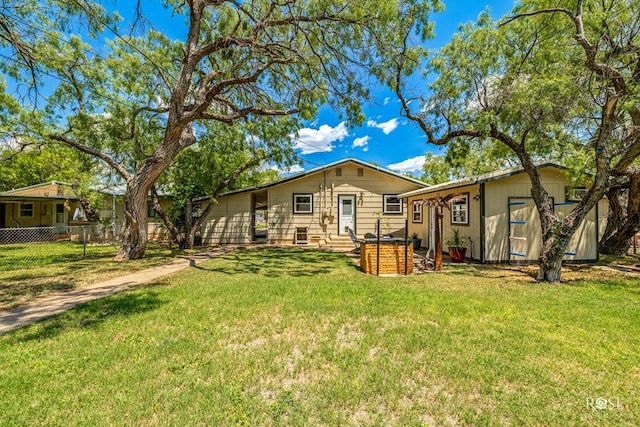 rear view of property featuring a lawn