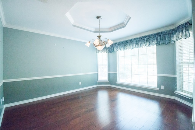 unfurnished room featuring hardwood / wood-style flooring, crown molding, a raised ceiling, and a notable chandelier