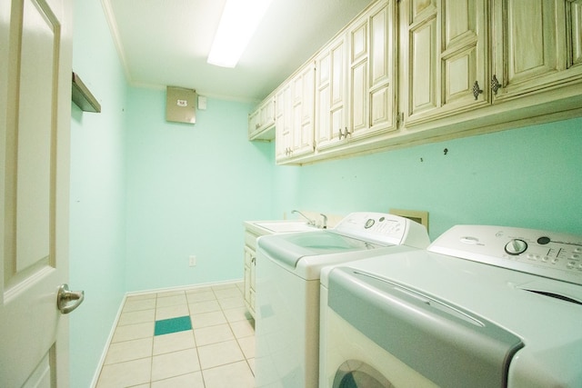 clothes washing area with washer and dryer, sink, cabinets, ornamental molding, and light tile patterned floors