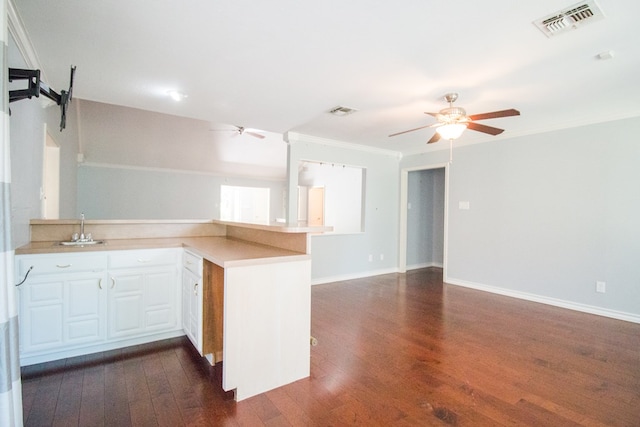 kitchen featuring ornamental molding, dark hardwood / wood-style floors, kitchen peninsula, ceiling fan, and white cabinets