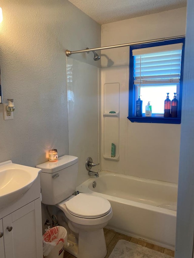 full bathroom featuring vanity, shower / bathing tub combination, toilet, and a textured ceiling