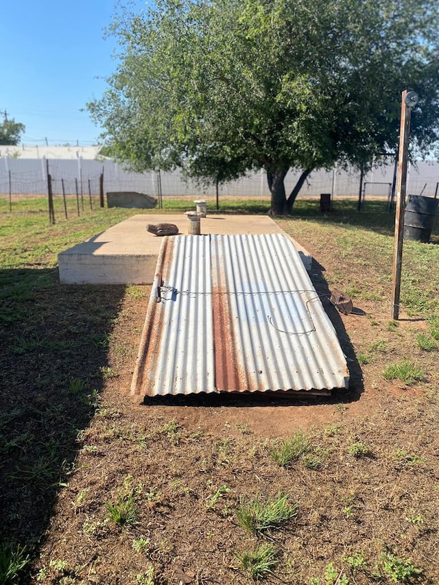 entry to storm shelter featuring a lawn