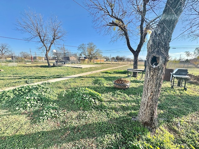 view of yard with a trampoline and an outdoor fire pit