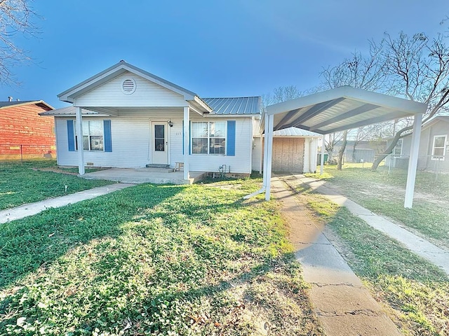 view of front facade with a carport, covered porch, and a front lawn