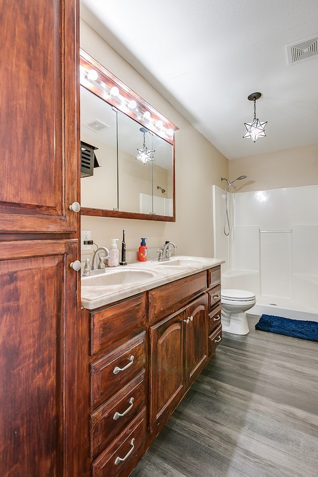 6376 Fm 380, San Angelo, TX 76905 - full bathroom featuring wood finished floors, double vanity, a shower, and toilet
