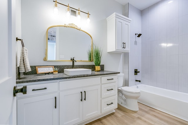 full bathroom featuring vanity, toilet, tiled shower / bath combo, and hardwood / wood-style floors