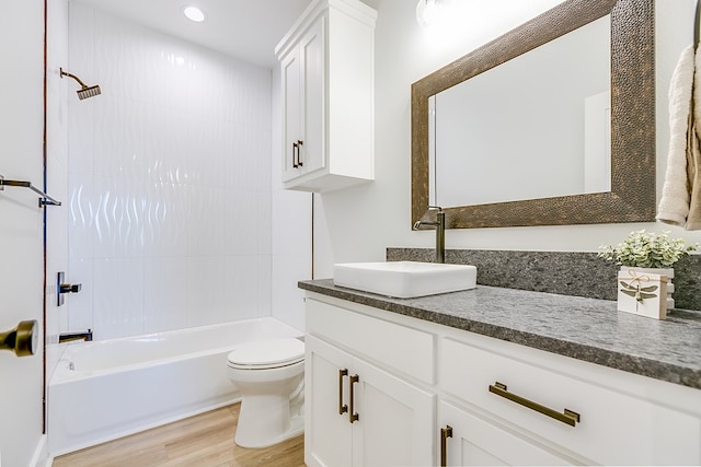 full bathroom featuring vanity, toilet, tiled shower / bath combo, and hardwood / wood-style floors