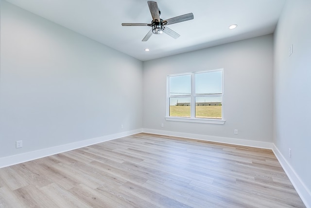 empty room with ceiling fan and light hardwood / wood-style floors