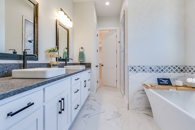 bathroom with tile walls, vanity, and a tub