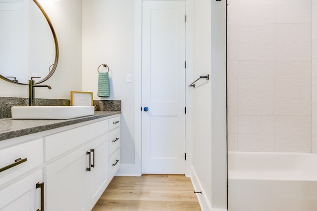 bathroom with vanity, shower / washtub combination, and hardwood / wood-style floors