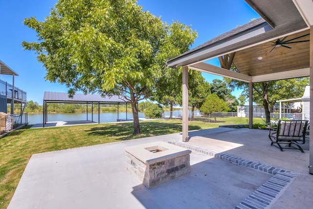 view of patio featuring a gazebo, a water view, ceiling fan, and an outdoor fire pit