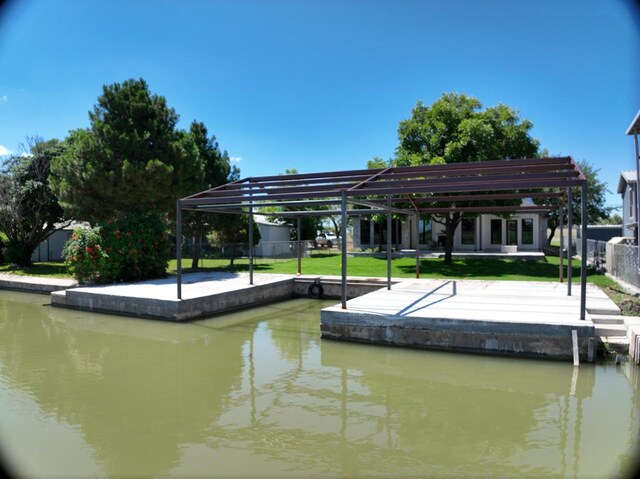 view of dock with a water view and a lawn