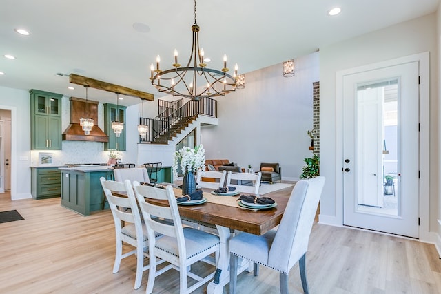 dining space with beam ceiling and light hardwood / wood-style floors