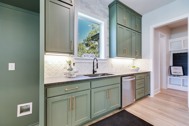 kitchen with sink, light hardwood / wood-style flooring, dishwasher, backsplash, and green cabinetry