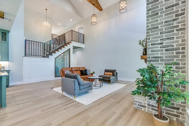 living room with beam ceiling, light wood-type flooring, a notable chandelier, and high vaulted ceiling