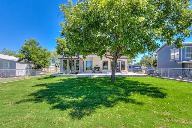 back of property with a yard and a patio area