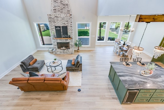 living room featuring a fireplace, light hardwood / wood-style floors, and a notable chandelier