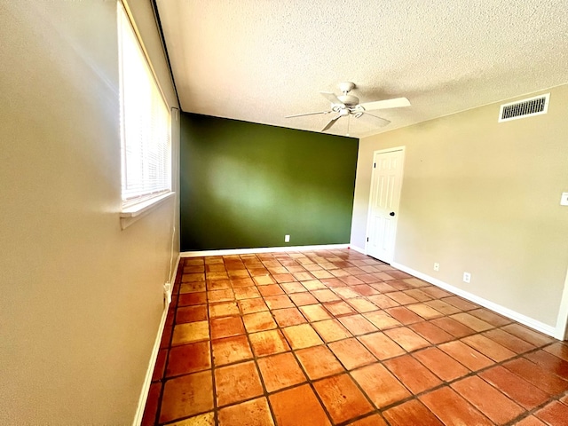 1013 Wynne Ave, San Angelo, TX 76905 - empty room featuring baseboards, a ceiling fan, a textured ceiling, and tile patterned flooring