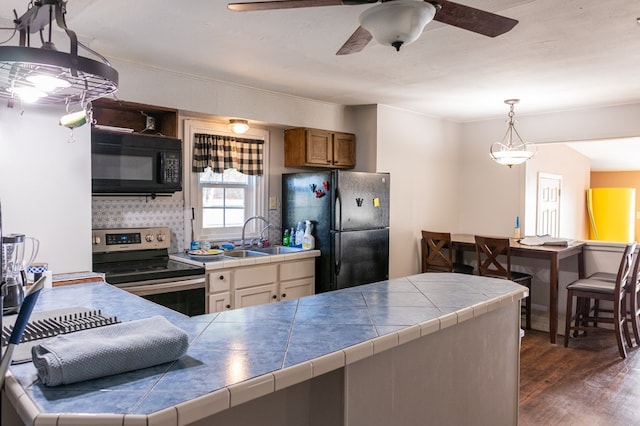 kitchen featuring sink, tile countertops, and black appliances