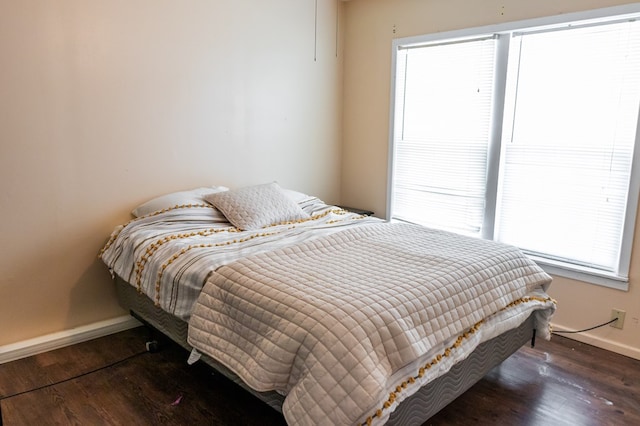 bedroom featuring multiple windows and dark hardwood / wood-style flooring