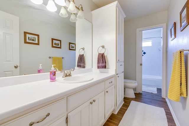 6038 Winners Cir, San Angelo, TX 76904 - bathroom with vanity, toilet, wood finished floors, a chandelier, and shower / tub combination