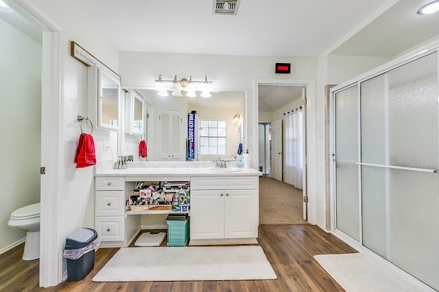 6038 Winners Cir, San Angelo, TX 76904 - full bathroom with wood finished floors, vanity, a shower stall, and toilet