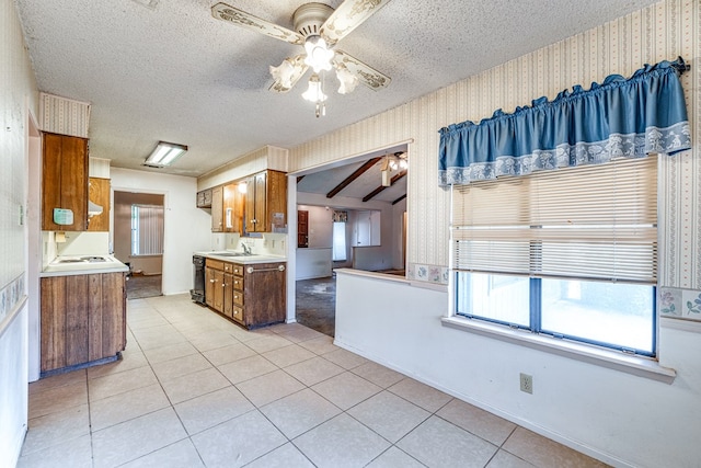 kitchen featuring sink, a textured ceiling, ceiling fan, and light tile patterned flooring