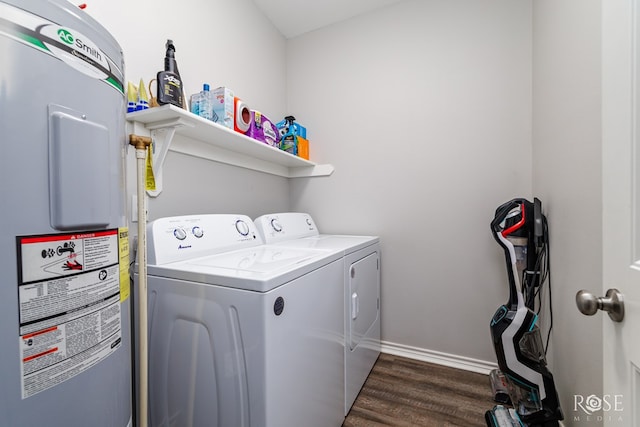 washroom with dark hardwood / wood-style flooring, electric water heater, and washing machine and dryer