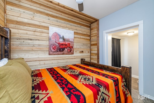 carpeted bedroom featuring wooden walls