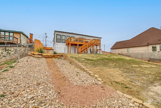 back of house with a wooden deck and a lawn