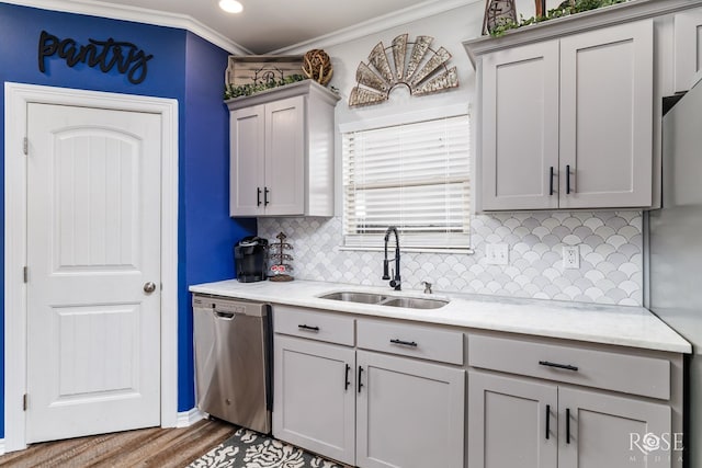 kitchen featuring sink, gray cabinets, appliances with stainless steel finishes, hardwood / wood-style floors, and ornamental molding