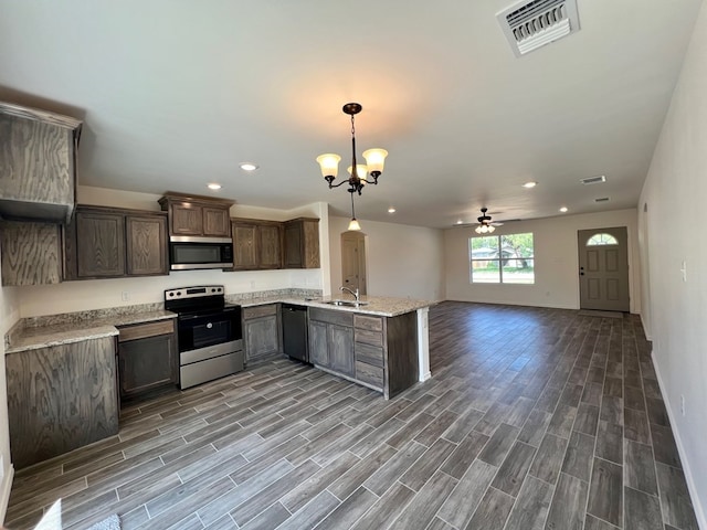 kitchen featuring appliances with stainless steel finishes, ceiling fan with notable chandelier, sink, hanging light fixtures, and dark brown cabinets