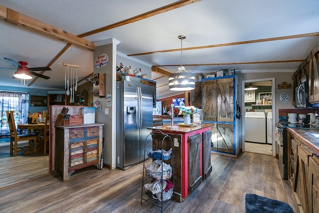 kitchen with dark hardwood / wood-style flooring, a center island, stainless steel appliances, crown molding, and washing machine and dryer