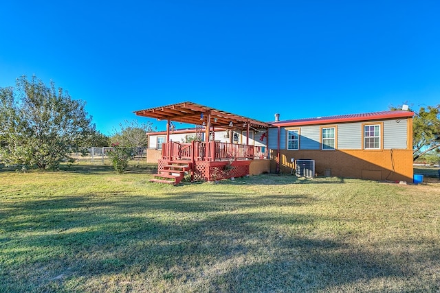 rear view of property with cooling unit, a deck, and a lawn