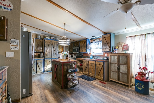 kitchen featuring dark hardwood / wood-style flooring, crown molding, stainless steel appliances, and a textured ceiling