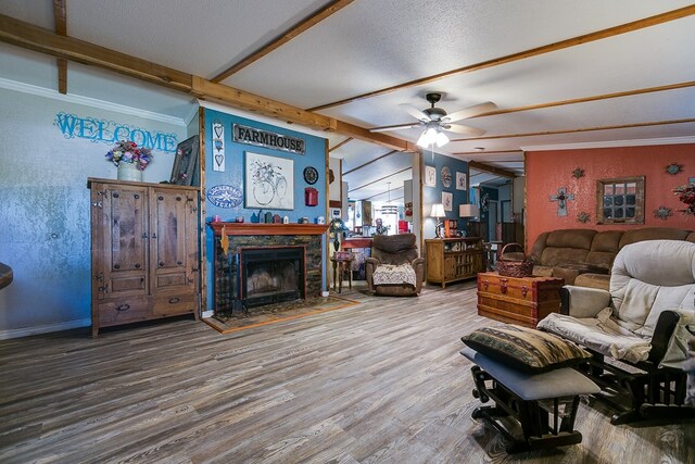 living room featuring crown molding, ceiling fan, wood-type flooring, lofted ceiling with beams, and a textured ceiling